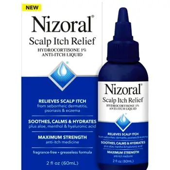 Close-up of hands parting hair to apply liquid solution directly to the scalp using a dropper