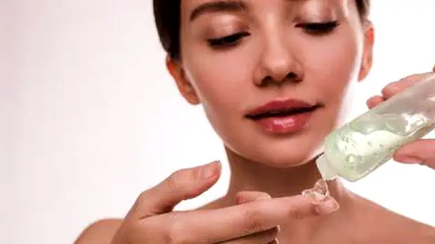 Person gently applying a thin layer of clear gel across the cheek with fingertips