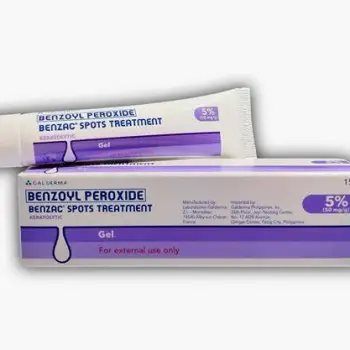 Hand holding a tube of benzoyl peroxide acne gel