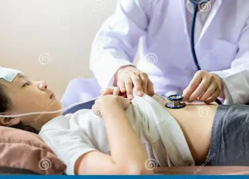Clinician using a stethoscope to listen to a patient's abdomen during a physical examination