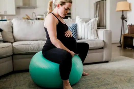 Person walking or swaying on a birth ball during early labor, showing the mobility and position changes suggested for managing early contractions.