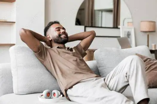 Person reclining on a sofa in a quiet room while another person checks on them