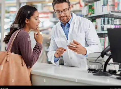 Pharmacist talking with a customer about allergy medicine at a pharmacy counter