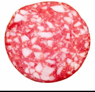 Thin slice of cured salami arranged on a wooden cutting board