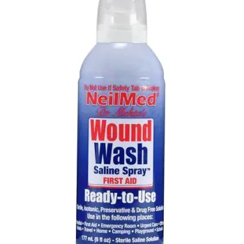 Packaged sterile saline wound wash spray bottle next to clean disposable cleaning materials
