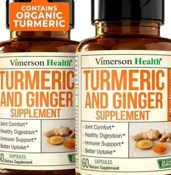 Fresh turmeric root placed next to a bottle of dietary supplement capsules on a table