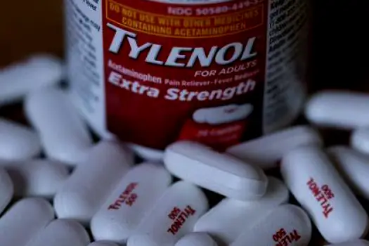 Warfarin prescription bottle next to a Tylenol Regular Strength bottle on a counter